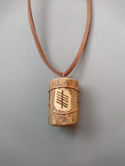 A wooden pendant with the Ogham sign for Elder burned into it.