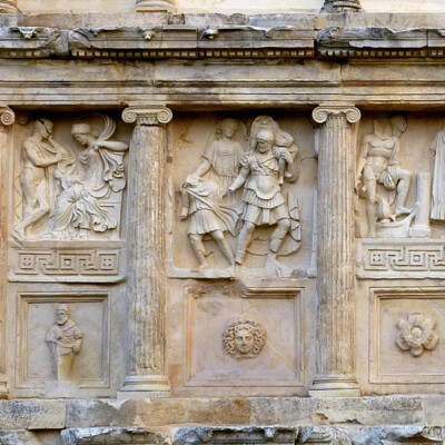 Description from the Aphrodisias Excavations website: “The armored figure of Aineias moves to the right, carrying his aged father on his shoulder and leading his young son Iulus by the hand. Old Anchises carries a round base or box that held images of Troy’s ancestral gods. These three figures constituted the regular iconographic scheme of Aineias’ flight from Troy, on his way to Italy, which was widespread in the early imperial period. The local designers have added a floating figure of Aphrodite behind to give the scene a more specific, local meaning. The relief was carved from a large block that contained serious flaws in the stone, resulting in the oblique brown-stained breaks; they represent the fault-lines.”