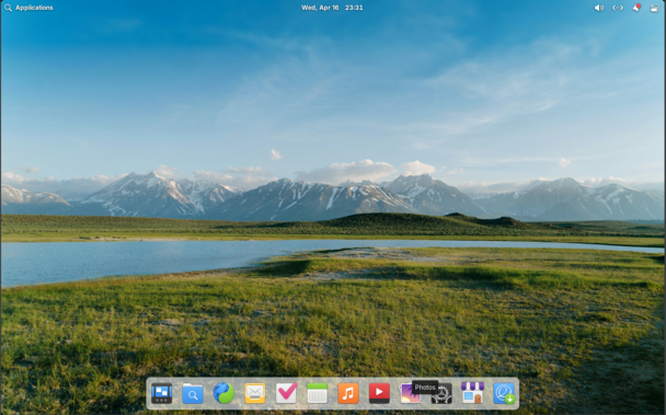 Fresh Elementary OS desktop background is a grassy field with lakes and mountains in the distance. App Search floats atop the screen, A row of app icons is along the bottom of the screen in a very MacOS fashion.